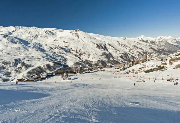 背景为村的高山冬季度假胜地俯瞰滑雪场 — 图库照片