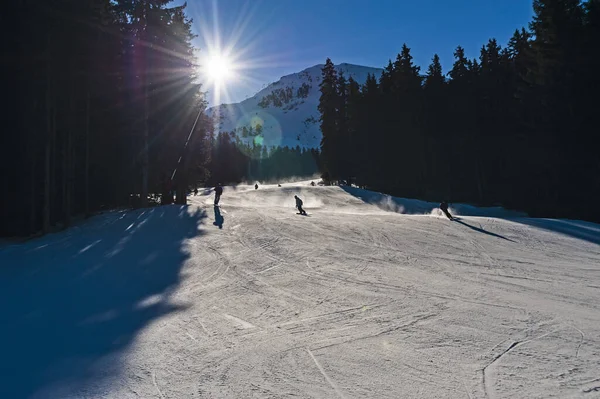 冬季高山度假胜地滑雪者滑向滑雪场的全景山谷景观 图库图片