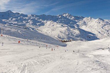 Dağdaki kayakçılarla birlikte bir kış sporu pistine bakın.