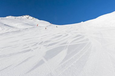 Panoramik manzara vadisi, kış Alp Dağları 'ndaki bir kayak pistini geziyor.