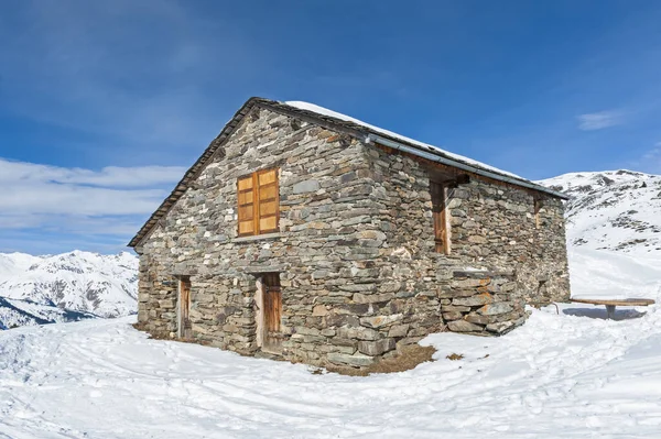 雪に覆われた冬の高山斜面にあるリモート石造りの家小屋 — ストック写真