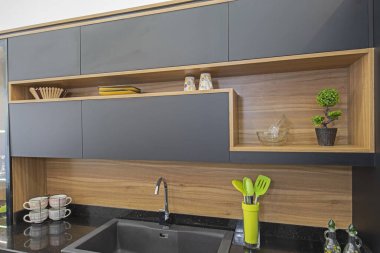 Modern mutfağı lüks apartman galerisindeki dolaplarla gösteren iç dizayn dekorasyonu.