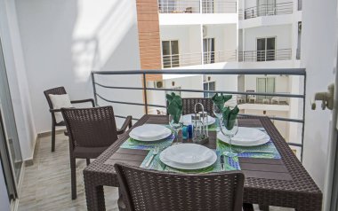 Plastik yemek masası mobilyalı, tropik bir tatil köyünde lüks bir dairenin teras mobilyaları.