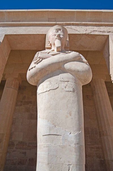 Большая статуя у входа в древний египетский храм Хатшетап в Луксоре с колоннами

