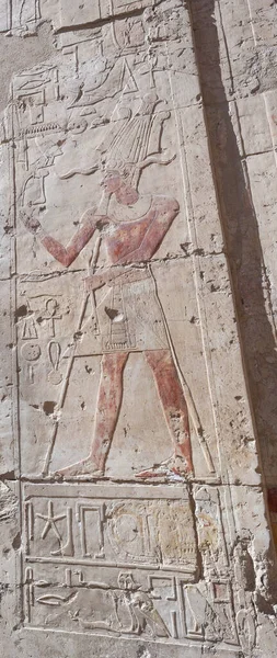 Hieroglypic carvings and paintings on wall at the ancient egyptian temple of hatshetup in Luxor