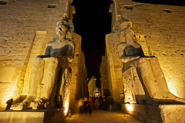 古埃及卢克索神庙入口处夜间点亮的拉美西斯二世的巨大雕像和象形文字雕塑 — 图库照片
