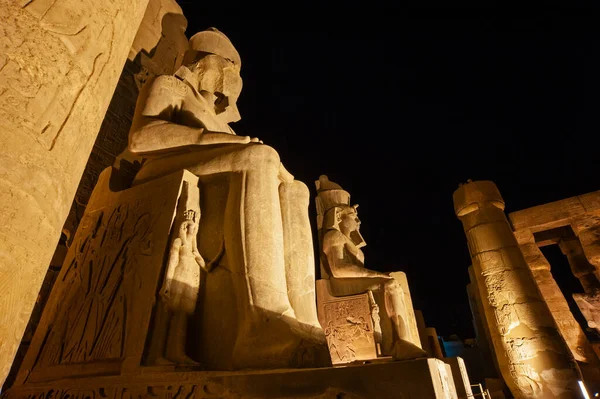 夜间点亮的古埃及卢克索神庙的巨大雕像和拉美西斯二世的象形文字雕刻 — 图库照片