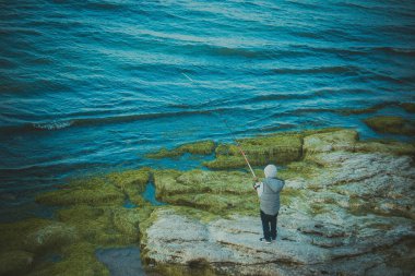 Fisher, balıkçılıkta büyük bir Atlantik somon balığı tutuyor.