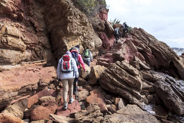 徒步旅行者在靠近海边的岩石上行走 — 图库照片