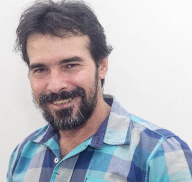 İlginç bir şey bakar ve gülümser bir mavi ekose gömlek giydiği Siyah sakallı, biraz gri, beyaz bir adam