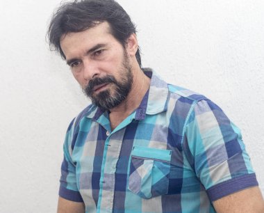 Bir beyazın Siyah sakallı, birkaç gri saç, mavi ekose gömlek giyer, bir şey ilginç, farklı pozisyonlarda ellerini jestlerle bakar.