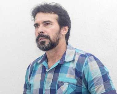 Bir beyazın Siyah sakallı, birkaç gri saç, mavi ekose gömlek giyer, bir şey ilginç, farklı pozisyonlarda ellerini jestlerle bakar.