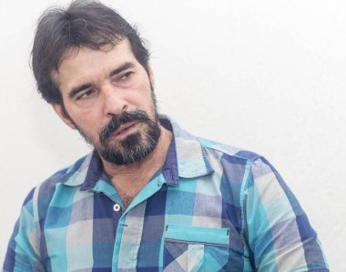 Bir beyazın Siyah sakallı, birkaç gri saç, mavi ekose gömlek giyer, bir şey ilginç, farklı pozisyonlarda ellerini jestlerle bakar.