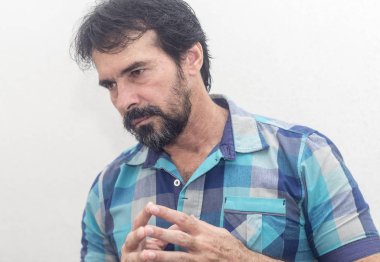 Bir beyazın Siyah sakallı, birkaç gri saç, mavi ekose gömlek giyer, bir şey ilginç, farklı pozisyonlarda ellerini jestlerle bakar.