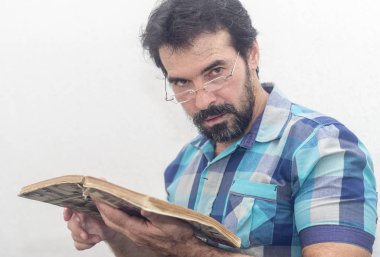 Seyir bir kitap bir mavi ekose gömlek giymiş bir beyazın Siyah sakallı, gri saçlar, gözlük,