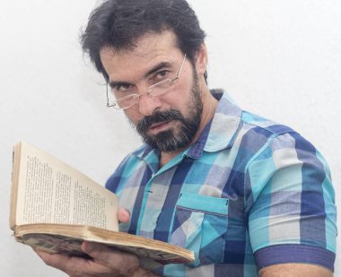 Seyir bir kitap bir mavi ekose gömlek giymiş bir beyazın Siyah sakallı, gri saçlar, gözlük,
