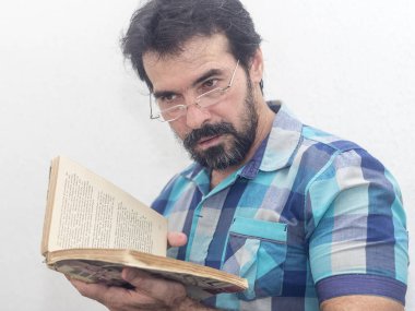 Seyir bir kitap bir mavi ekose gömlek giymiş bir beyazın Siyah sakallı, gri saçlar, gözlük,