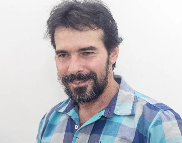 İlginç bir şey bakar ve gülümser bir mavi ekose gömlek giydiği Siyah sakallı, biraz gri, beyaz bir adam