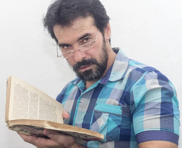 Seyir bir kitap bir mavi ekose gömlek giymiş bir beyazın Siyah sakallı, gri saçlar, gözlük,