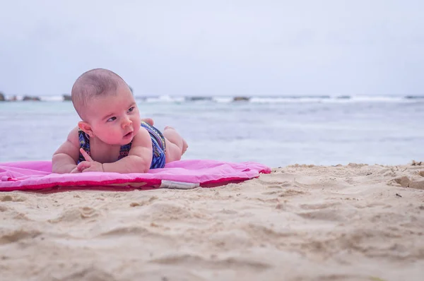 Bebé en la playa acostado en la alfombra rosa arena —  Fotos de Stock