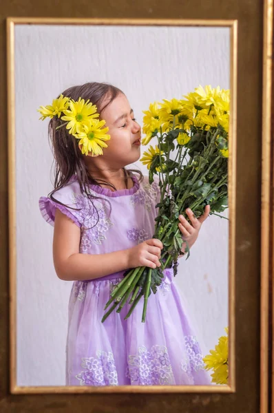 Menina com flores amarelas no quadro velho — Fotografia de Stock