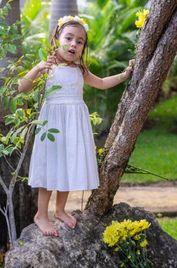 Ormanda taşın üstünde beyaz elbiseli bir kız.