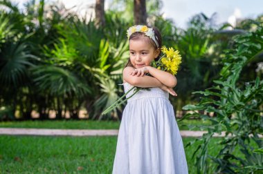 Ormanda taşın üstünde beyaz elbiseli bir kız.