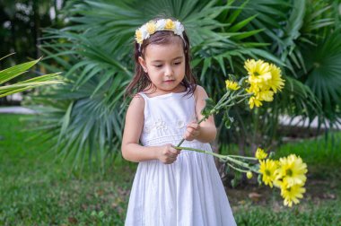 Ormanda taşın üstünde beyaz elbiseli bir kız.