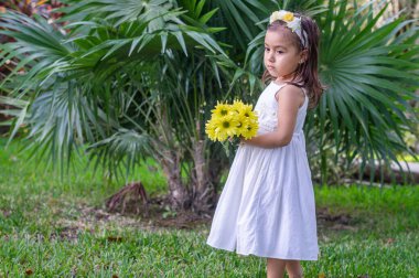 Ormanda taşın üstünde beyaz elbiseli bir kız.