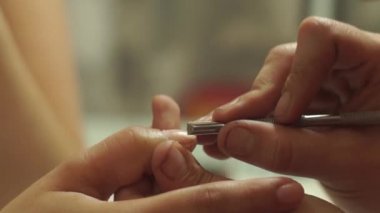 Genç bir kadının ellerinde tırnaklarını temizleme ve kesme, profesyonel manikür.