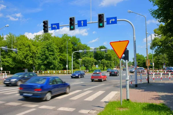 Escena urbana, coches cruzando la intersección con semáforos Imagen De Stock