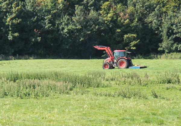 Ein Landwirtschaftlicher Traktor Mäht Das Gras Auf Einem Feld — Stockfoto