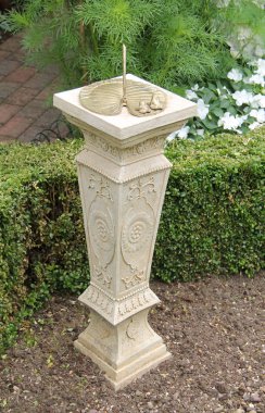 Bir süs taş ve Metal güneş saati bir Bahçe.