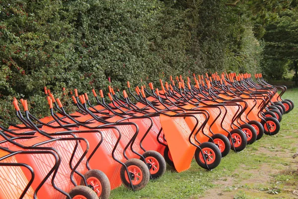 Large Collection Orange Plastic Wheelbarrows — Stock fotografie