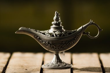 Ahşap yüzey üzerinde oturan gerçek Aladin tarzı güzel antika metal lamba
