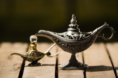 Ahşap yüzey üzerinde oturan gerçek Aladin tarzı, daha küçük modeli yanındaki yer güzel antika metal lamba