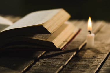 Bunun yanında, güzel bir gece ışık ayarı, sihirli kavramı ateş oturan ahşap yüzey, wax mum açık yatan kalın bir kitap