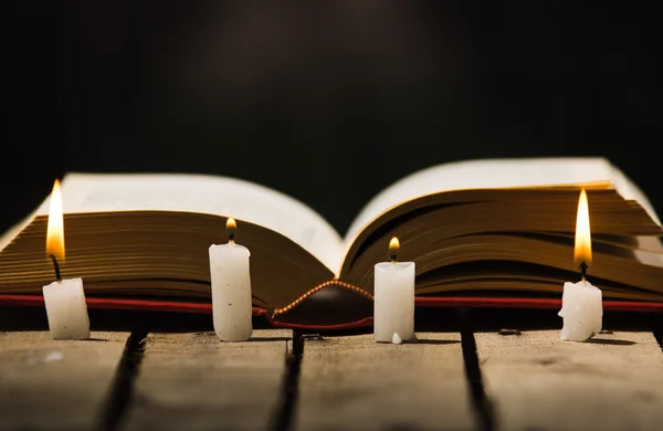 Tlusté knihy položené na dřevěnou desku, voskové svíčky umístěné vpředu, krásné noční světlo nastavení, magický pojem natáčení — Stock fotografie
