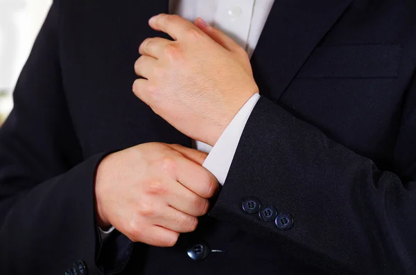 Closeup mans arm wearing suit, adjusting cufflinks using hands, men getting dressed concept — Stock Photo, Image