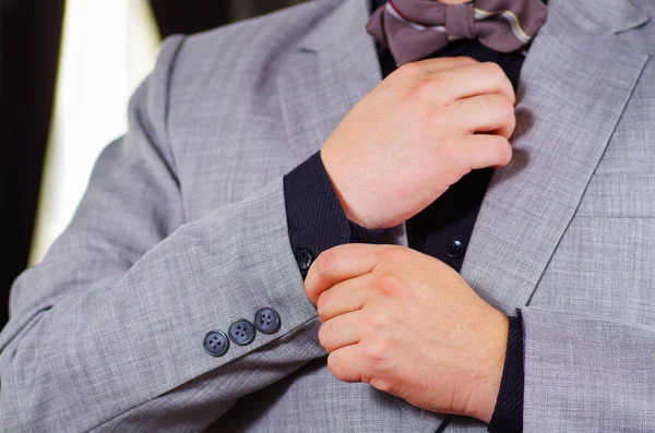 Closeup mans arm wearing suit, adjusting cufflinks using hands, men getting dressed concept — Stock Photo, Image