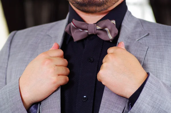 Closeup mans chest area wearing formal suit and bowtie, adjusting jacket collar using hands, men getting dressed concept — Stock Photo, Image