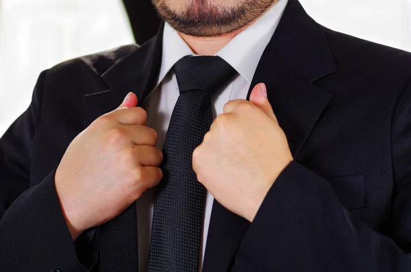 特写男子胸区穿正式西装打领带，用双手调整夹克领，男士着装概念 — 图库照片