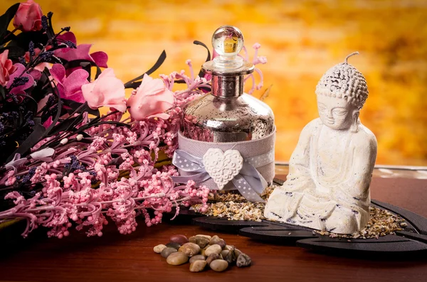 Skleněné láhve a buddha socha s květy spa koncept — Stock fotografie