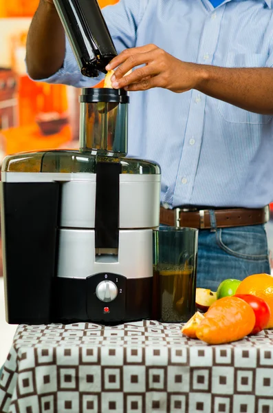 Primer plano mans manos usando jugo fabricante, insertar piezas de manzana en la máquina, concepto de estilo de vida saludable —  Fotos de Stock