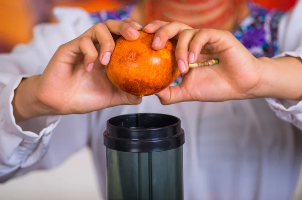 Closeup dames handen met sap maker, granadilla invoegen in machine kamer, gezonde levensstijl concept — Stockfoto