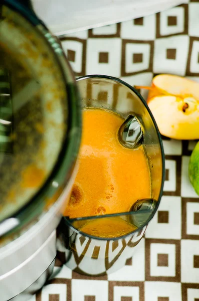 Primo piano creatore esclusivo succo visto dall'alto, prodotto liquido arancione finito in ciotola collegato alla macchina, concetto di stile di vita sano — Foto Stock