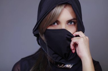 Eşleşen peçe ayarlama el, kullanarak kamera, ninja kavramı karşı karşıya tutan siyah, giyimli samuray kadın