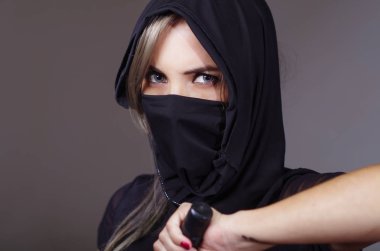 Samuray kadın yüz kapsayan, bakan kılıç kamera ninja kavramı ele sahip eşleşen örtü ile siyah giyimli