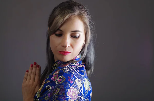 Samurai woman dressed in traditional colorful flower pattern asian silk dress, holding hands together as in praying, seen from profile angle, ninja concept — Stock Photo, Image