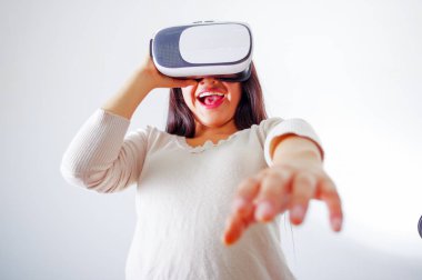 Geleceğin teknolojisi yaşıyor, etkileşim ve oynarken, stüdyo arka plan, vr kavramı gülümseyen sanal gerçeklik giyen genç esmer kadın gözlüğü